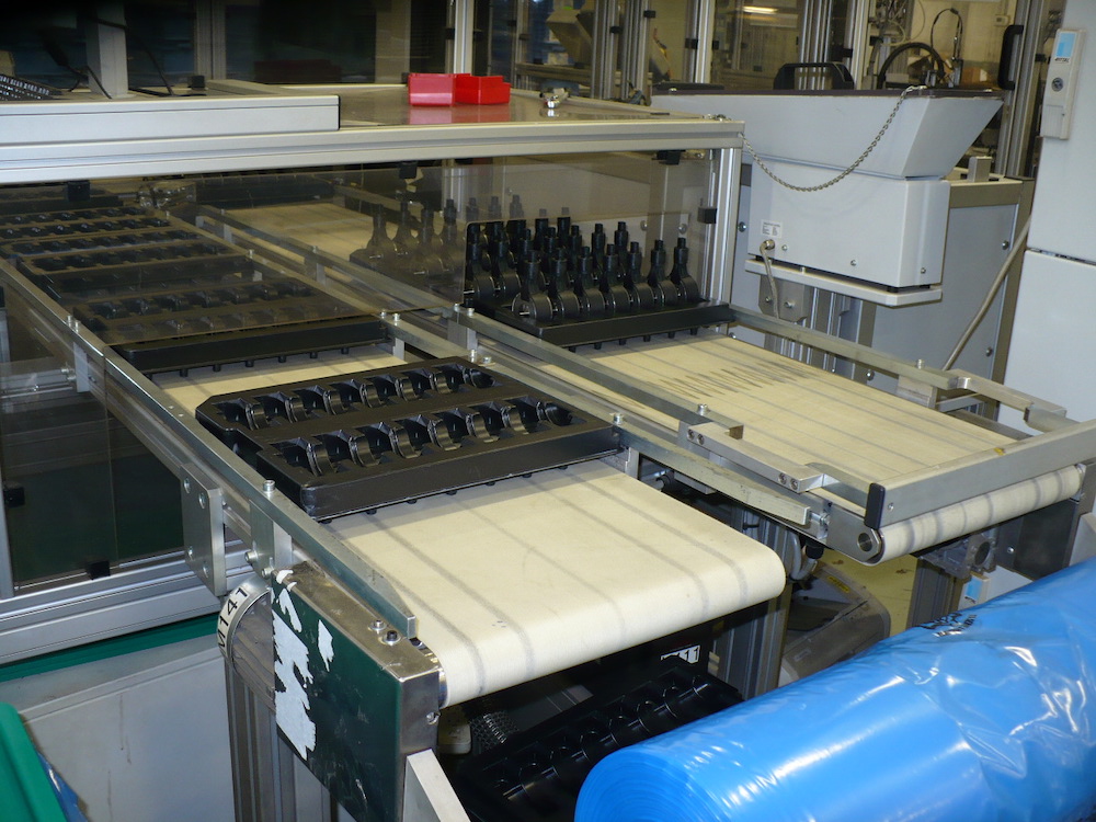 Trays on belt conveyors
